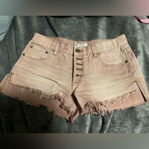 Pink distressed exposed button front denim shorts by Free People